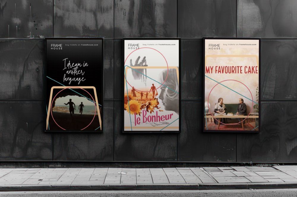 Frame House movie posters on a street wall